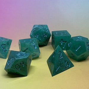 A handcrafted set of seven Jade Veil resin dice, featuring swirling green patterns with elegant blue-inked numbers, displayed against a pastel gradient background.
