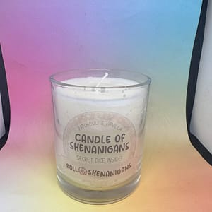 “Candle of Shenanigans Patchouli and Vanilla scented candle with secret mystery dice inside, made by Roll 4 Shenanigans, displayed against a pastel gradient background.”